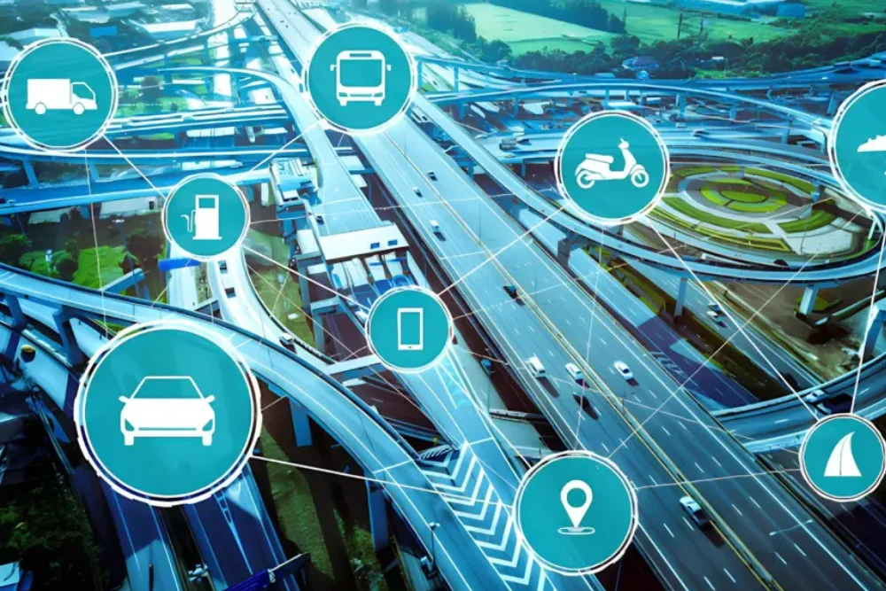 Vista de cima de uma cidade, com carros nas avenidas, e símbolos de veículos acima, representando a telemetria veicular.